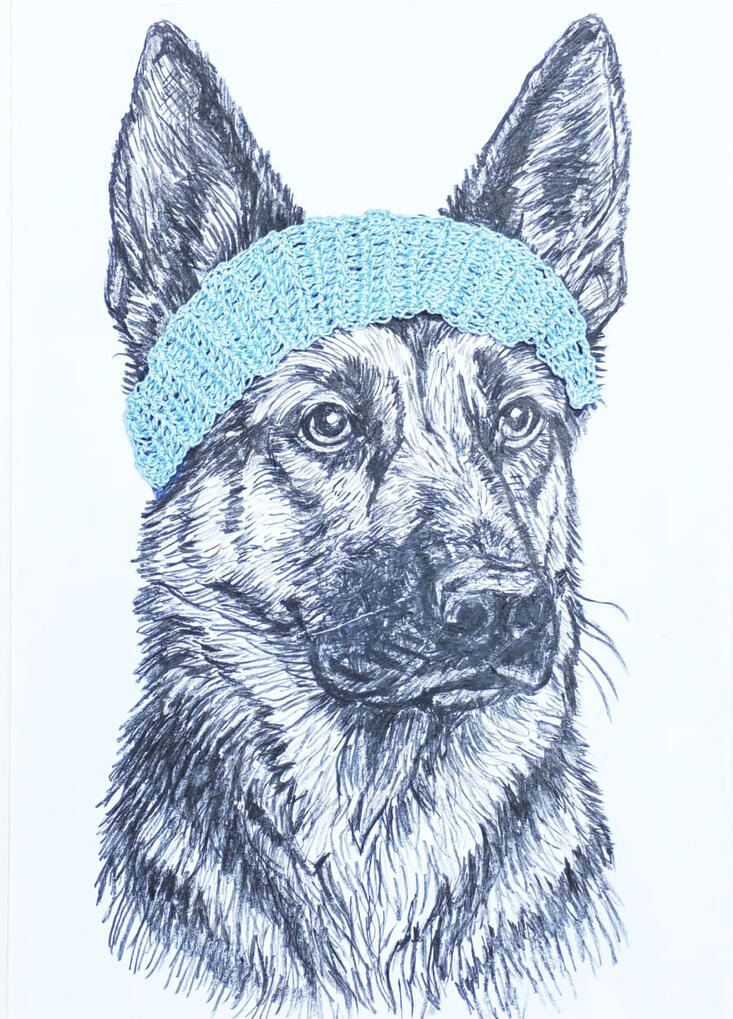 Perro pastor alemán con complemento crochet felpa de color celeste.