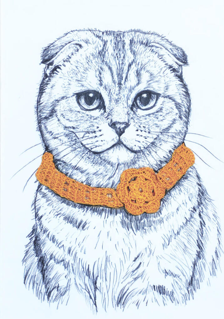 Gato Scotish Fold sin orejas con complemento collar con flor de crochet color naranja.
